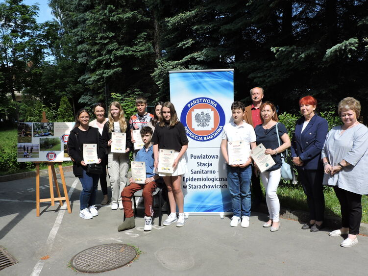 nagrodzeni uczniowie wraz z organizatorami w tle baner Inspekcji Sanitarnej